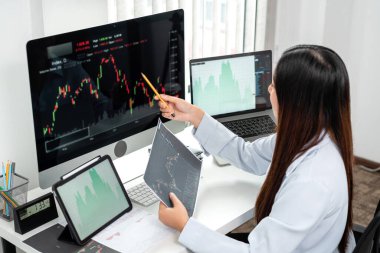 Bilgisayar, tablet ve grafik borsası planlama ve grafik veri yatırım planlama ile çalışan iş kadını yatırımcı.