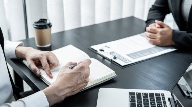 İş kadını adayı, iş görüşmesinde özgeçmiş okuyan komite başkanı ve işe alım görevlisine profilini sunar ve açıklar..