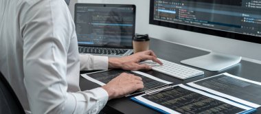 Masaüstü bilgisayarında yazılım geliştirme projesinde çalışan profesyonel programcı, kodlama yapıyor ve veri kodu şifresi güvenliği yazıyor.