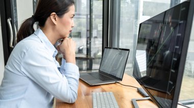 İş kadını yatırımcı, bir borsada sunulan verileri ekranda göstererek grafik verilerini planlayıp analiz ediyor..