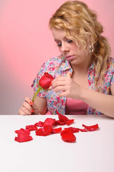 Ξανθιά γυναίκα λαμβάνει τα πέταλα ενός τριαντάφυλλου — Φωτογραφία Αρχείου