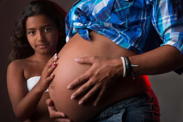 Young girl touching pregnant belly — Stock Photo, Image