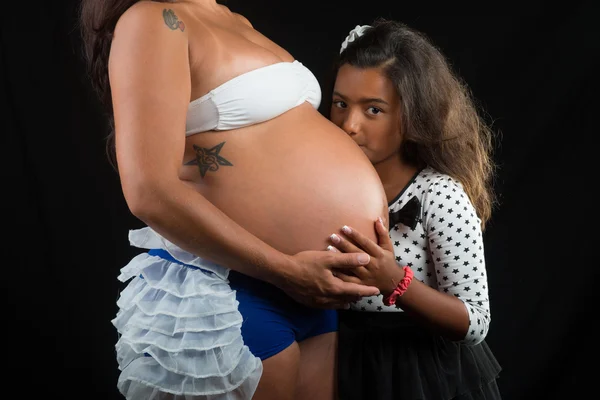 Girl kissing her pregnant mother belly — Stock Photo, Image