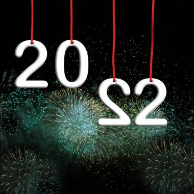 Mutlu yıllar 2022. Kırmızı sicimde asılı beyaz sayılar. Arka planda havai fişekler