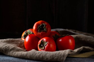 Ahşap arka planda olgun hurma. hurma eriği ya da Sharon meyvesi. Kaki hurma meyvesi. Yerel yemek..