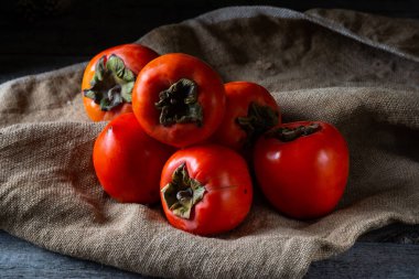 Ahşap arka planda olgun hurma. hurma eriği ya da Sharon meyvesi. Kaki hurma meyvesi. Yerel yemek..