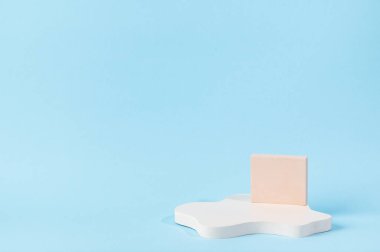 Ürün sunumu için minimum soyut kozmetik arka plan. Mavi arka planda kozmetik şişe podyumu. Pastel renkler, geometrik formlarla biçimlendirilmiş kompozisyon. Minimum konsept. Ürün modeli..