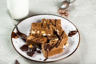 Fıstıklı Halva dilimleri, ahşap bir yüzeyde ceviz ve çay.