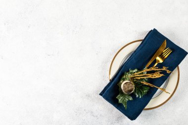 Beyaz arka planda modern bulaşık takımları ve süslemeleri olan bir Noel masası. Üst Manzara. Yeni yıl yeri ayarlama. Süslü Noel sofra takımı. Noel yeri ayarlama