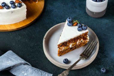 Koyu arkaplanda cevizli ve yaban mersinli havuçlu kek. Yerel yemek. Geleneksel Amerikan pastası. Şükran Günü için pasta. Noel pastası