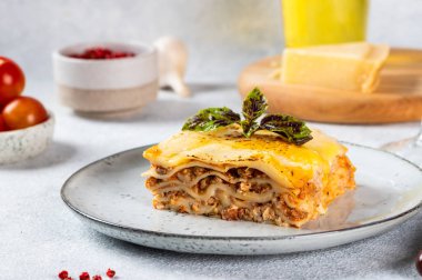 Hafif arka planda lezzetli bir lazanya parçası. Geleneksel İtalyan lazanyası. İtalyan yemeği. Lazanyayı kapat. Bolonez sosu. Sos haline geldi. Hala yiyecek dolu bir hayat. Ev yapımı et lazanyası..