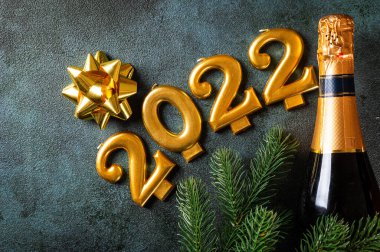 Şampanya şişesi ve dekorlu 2022 numara. Mutlu yıllar ve festival konsepti. Üst yatay görünüm telif uzayı. Yeni Yıl 'da. Noel beşiği. Yeni yıl 2022. Yeni yıl kavramı
