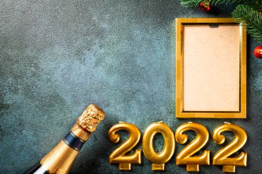 Noel fotoğraf çerçevesi koyu arkaplanda süsleme ile şablon oluşturur. Yukarıdan bak. Yeni yıl modeli. Şampanya şişesi ve dekorla yeni yıl kompozisyonu. Yeni yıl 2022.