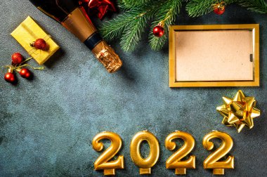 Noel fotoğraf çerçevesi koyu arkaplanda süsleme ile şablon oluşturur. Yukarıdan bak. Yeni yıl modeli. Şampanya şişesi ve dekorla yeni yıl kompozisyonu. Yeni yıl 2022.