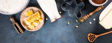 Noel afişi. Noel pastası arka planı. Karanlık arka planda Noel yemeği pişirmek için gerekli malzemeler. Kopyalama alanı olan üst görünüm. Zencefilli kurabiye. Zencefilli kurabiye pişirmek. Çiğ satıldı.