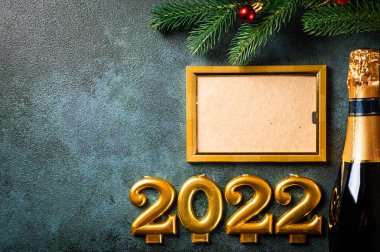 Noel fotoğraf çerçevesi koyu arkaplanda süsleme ile şablon oluşturur. Yukarıdan bak. Yeni yıl modeli. Şampanya şişesi ve dekorla yeni yıl kompozisyonu. Yeni yıl 2022