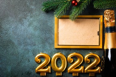Noel fotoğraf çerçevesi koyu arkaplanda süsleme ile şablon oluşturur. Yukarıdan bak. Yeni yıl modeli. Şampanya şişesi ve dekorla yeni yıl kompozisyonu. Yeni yıl 2022