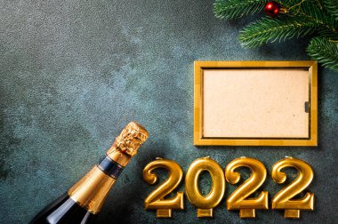 Noel fotoğraf çerçevesi koyu arkaplanda süsleme ile şablon oluşturur. Yukarıdan bak. Yeni yıl modeli. Şampanya şişesi ve dekorla yeni yıl kompozisyonu. Yeni yıl 2022