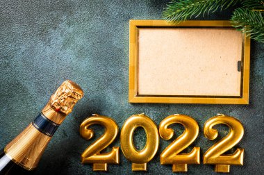 Noel fotoğraf çerçevesi koyu arkaplanda süsleme ile şablon oluşturur. Yukarıdan bak. Yeni yıl modeli. Şampanya şişesi ve dekorla yeni yıl kompozisyonu. Yeni yıl 2022