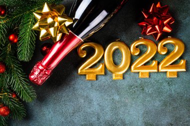 Şampanya şişesi ve dekorlu 2022 numara. Mutlu yıllar ve festival konsepti. Üst yatay görünüm, telif uzayı. Yeni Yıl 'da. Noel beşiği. Yeni yıl 2022. Yeni yıl kavramı.