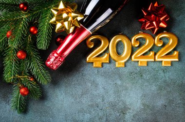 Şampanya şişesi ve dekorlu 2022 numara. Mutlu yıllar ve festival konsepti. Üst yatay görünüm, telif uzayı. Yeni Yıl 'da. Noel beşiği. Yeni yıl 2022. Yeni yıl kavramı.