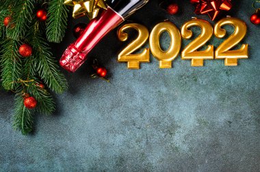 Şampanya şişesi ve dekorlu 2022 numara. Mutlu yıllar ve festival konsepti. Üst yatay görünüm, telif uzayı. Yeni Yıl 'da. Noel beşiği. Yeni yıl 2022. Yeni yıl kavramı.