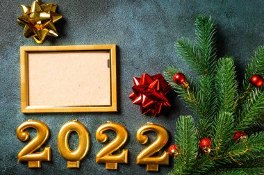 Noel fotoğraf çerçevesi koyu arkaplanda süsleme ile şablon oluşturur. Yukarıdan bak. Yeni yıl modeli. Şampanya şişesi ve dekorla yeni yıl kompozisyonu. Yeni yıl 2022.
