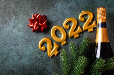 Şampanya şişesi ve dekorlu 2022 numara. Mutlu yıllar ve festival konsepti. Üst yatay görünüm telif uzayı. Yeni Yıl 'da. Noel beşiği. Yeni yıl 2022. Yeni yıl kavramı