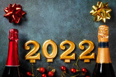 Şampanya şişesi ve dekorlu 2022 numara. Mutlu yıllar ve festival konsepti. Üst yatay görünüm telif uzayı. Yeni Yıl 'da. Noel beşiği. Yeni yıl 2022. Yeni yıl kavramı.