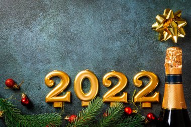 Şampanya şişesi ve dekorlu 2022 numara. Mutlu yıllar ve festival konsepti. Üst yatay görünüm telif uzayı. Yeni Yıl 'da. Noel beşiği. Yeni yıl 2022. Yeni yıl kavramı.