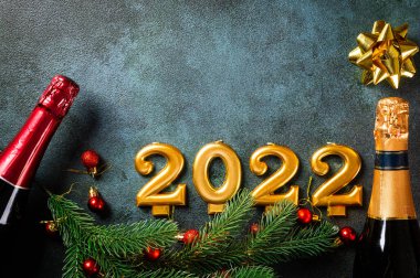 Şampanya şişesi ve dekorlu 2022 numara. Mutlu yıllar ve festival konsepti. Üst yatay görünüm telif uzayı. Yeni Yıl 'da. Noel beşiği. Yeni yıl 2022. Yeni yıl kavramı.