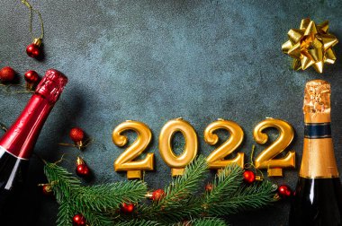 Şampanya şişesi ve dekorlu 2022 numara. Mutlu yıllar ve festival konsepti. Üst yatay görünüm telif uzayı. Yeni Yıl 'da. Noel beşiği. Yeni yıl 2022. Yeni yıl kavramı.