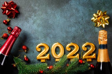 Şampanya şişesi ve dekorlu 2022 numara. Mutlu yıllar ve festival konsepti. Üst yatay görünüm telif uzayı. Yeni Yıl 'da. Noel beşiği. Yeni yıl 2022. Yeni yıl kavramı.