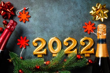 Şampanya şişesi ve dekorlu 2022 numara. Mutlu yıllar ve festival konsepti. Üst yatay görünüm telif uzayı. Yeni Yıl 'da. Noel beşiği. Yeni yıl 2022. Yeni yıl kavramı.