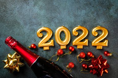 Şampanya şişesi ve dekorlu 2022 numara. Mutlu yıllar ve festival konsepti. Üst yatay görünüm telif uzayı. Yeni Yıl 'da. Noel beşiği. Yeni yıl 2022. Yeni yıl kavramı.