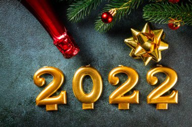 Şampanya şişesi ve dekorlu 2022 numara. Mutlu yıllar ve festival konsepti. Üst yatay görünüm telif uzayı. Yeni Yıl 'da. Noel beşiği. Yeni yıl 2022. Yeni yıl kavramı.