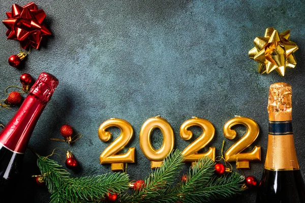Şampanya şişesi ve dekorlu 2022 numara. Mutlu yıllar ve festival konsepti. Üst yatay görünüm telif uzayı. Yeni Yıl 'da. Noel beşiği. Yeni yıl 2022. Yeni yıl kavramı.