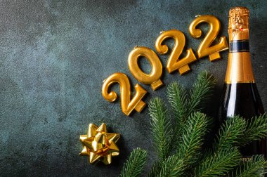 Şampanya şişesi ve dekorlu 2022 numara. Mutlu yıllar ve festival konsepti. Üst yatay görünüm telif uzayı. Yeni Yıl 'da. Noel beşiği. Yeni yıl 2022. Yeni yıl kavramı.