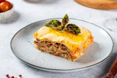 Hafif arka planda lezzetli bir lazanya parçası. Geleneksel İtalyan lazanyası. İtalyan yemeği. Lazanyayı kapat. Bolonez sosu. Sos haline geldi. Hala yiyecek dolu bir hayat. Ev yapımı et lazanyası.