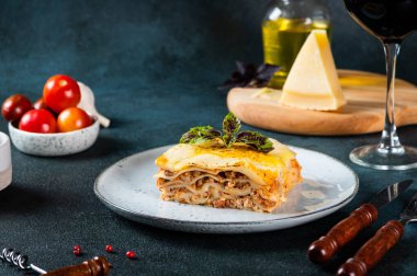 Koyu arkaplanda lezzetli bir lazanya. Geleneksel İtalyan lazanyası. İtalyan yemeği. Lazanyayı kapat. Bolonez sosu. Sos haline geldi. Hala yiyecek dolu bir hayat. Ev yapımı et lazanyası.
