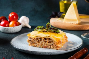 Koyu arkaplanda lezzetli bir lazanya. Geleneksel İtalyan lazanyası. İtalyan yemeği. Lazanyayı kapat. Bolonez sosu. Sos haline geldi. Hala yiyecek dolu bir hayat. Ev yapımı et lazanyası..