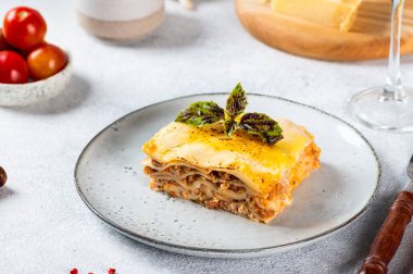 Hafif arka planda lezzetli bir lazanya parçası. Geleneksel İtalyan lazanyası. İtalyan yemeği. Lazanyayı kapat. Bolonez sosu. Sos haline geldi. Hala yiyecek dolu bir hayat. Ev yapımı et lazanyası..