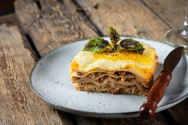 Koyu arkaplanda lezzetli bir lazanya. Geleneksel İtalyan lazanyası. İtalyan yemeği. Lazanyayı kapat. Bolonez sosu. Sos haline geldi. Hala yiyecek dolu bir hayat. Ev yapımı et lazanyası.