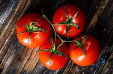 Tahta bir masada taze olgun domatesler. Taze sebzeler. Daldaki domatesler. Organik sebzeler.