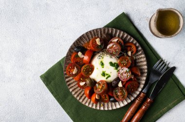 Dilimlenmiş domatesli İtalyan caprese salatası, mozzarella, sarımsak, hafif arka planda zeytinyağı. Üst Manzara. İtalyan yemeği. Sağlıklı yemek, burrata salatası..
