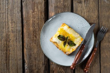 Lezzetli bir parça kırmızı şaraplı lazanya. Küçük bir alan derinliği. Geleneksel İtalyan lazanyası. Porsiyon. İtalyan yemeği. Siyah tabakta yemek. Bolonez sosu. Sos haline geldi. Yemek dolu bir hayat..