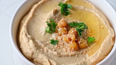 Susamlı humus ve zeytinyağı yakın çekim. Sağlıklı vejetaryen yemeği. Humus dönüşü. Vejetaryen yemeği. Mezze nohutları. Koşer yemeği..