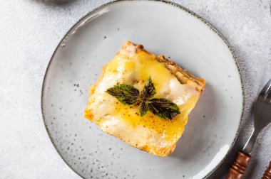 Koyu arkaplanda lezzetli bir lazanya. Geleneksel İtalyan lazanyası. İtalyan yemeği. Lazanyayı kapat. Bolonez sosu. Sos haline geldi. Hala yiyecek dolu bir hayat. Ev yapımı et lazanyası.