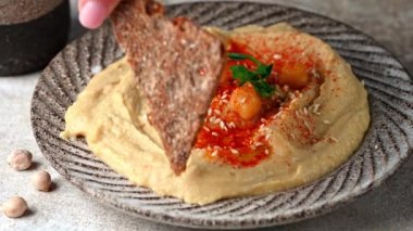 Cips ve humus yiyorum. Susamlı humus, zeytinyağı ve kırmızı biber. Sağlıklı vejetaryen yemeği. Vejetaryen yemeği. Mezze nohutları. Koşer yemeği.