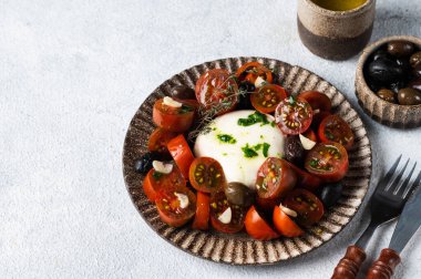 Dilimlenmiş domatesli İtalyan caprese salatası, mozzarella, sarımsak, hafif arka planda zeytinyağı. Üst Manzara. İtalyan yemeği. Sağlıklı yemek, burrata salatası..
